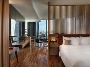 a hotel room with a large bed and a desk and a desk at SO/ Bangkok in Bangkok