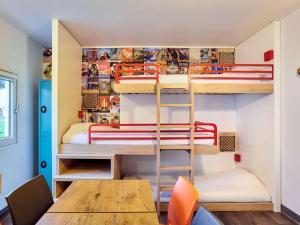 パリにあるHotelF1 Paris Saint Ouen Marché Aux Pucesの小さなお部屋で、二段ベッドとテーブルが備わります。