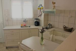 a kitchen with a table and a vase with flowers on it at Danaides Studios in Batsi +53 photos