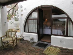 a room with a door and a chair on a patio at Casa Del Mar in Hermanus