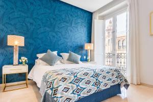 una camera blu con un letto con una parete blu di Apartamento Living By Cathedral a Siviglia