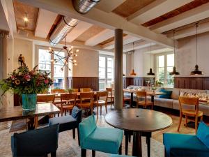 August Restaurant Hotel في Wolhusen: مطعم بطاولات وكراسي وأريكة