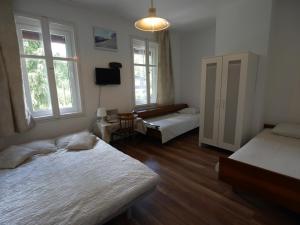 シュクラルスカ・ポレンバにあるIzerski Kamienのベッドルーム1室(ベッド2台、テレビ、窓2つ付)