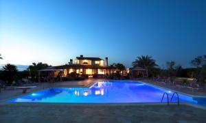 a large swimming pool in front of a house at Ferrocino Resort in Galatone