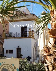 Ein weißes Gebäude mit einem Schild, das Casa madrococo liest in der Unterkunft Casa Madonia in Terrasini