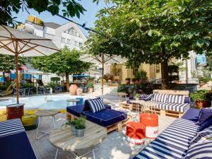 une terrasse avec des tables et des chaises bleues et blanches dans l'établissement August Restaurant Hotel, à Wolhusen