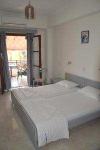 1 dormitorio con 2 camas y balcón en Friendly Studios, en Iräon