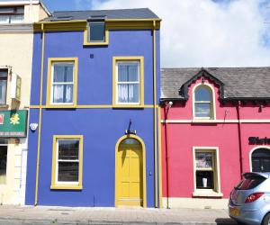 a colorful house with a yellow door on a street at Walter's Place in Carrickfergus