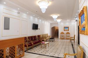 a lobby with a couch and chairs and a tv at Sea Hotel Apartment in Sur