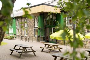 a group of picnic tables in front of a building at YHA Okehampton in Okehampton
