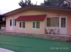 a small house with a green lawn in front of it at Вили Бийчхаус in Kranevo