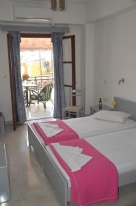 a bedroom with a bed and a balcony with a table at Friendly Studios in Ireon