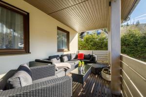 un patio con sofás y mesas en una terraza en Luxus Ferienhaus Feldberg, en Feldberg