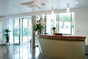 a woman sitting at a bar in a lobby at Club House Hotel in Rimini