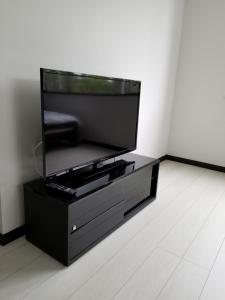 a black entertainment center with a flat screen tv at Furano Mount Villa in Furano