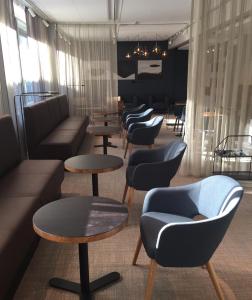 a living room filled with chairs and tables at Park Alandia Hotel in Mariehamn