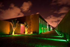 a building with green lights on a street at night at Union Motel (Adult Only) in Cabedelo