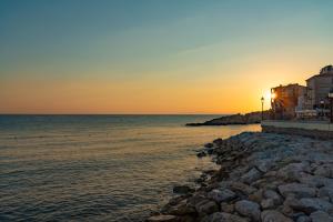 a sunset over the ocean next to a rocky beach at Marina Garden Hotel in Marciana Marina