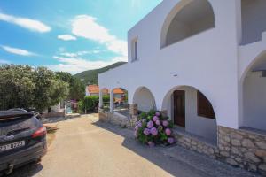 a white building with flowers on the side of it at Apartment Fiora in Zastražišće