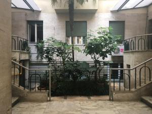 a building with stairs and plants in front of it at Rhome Suites in Rome