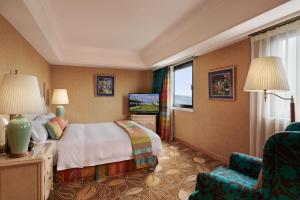 una camera d'albergo con letto e sedia di The Riviera Hotel Taipei a Taipei