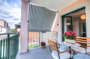 einen Balkon mit einem Tisch, Stühlen und Blumen in der Unterkunft Rita's Garden in San Vittore Olona