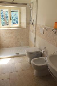 a bathroom with a toilet and a tub and a sink at Agriturismo Le Catre in Castagneto Carducci