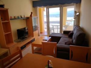a living room with a couch and a television at Duplex Tres Dormitorios Playa A Rapadoira in Foz