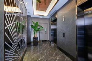 a hallway with elevators and a plant at Hotel 81 Orchid in Singapore