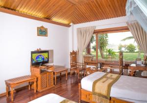 ein Schlafzimmer mit 2 Betten und einem TV in der Unterkunft KMA Kaytumadi Hotel in Taungoo