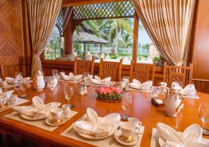 uma longa mesa de madeira com pratos e copos em KMA Kaytumadi Hotel em Taungoo