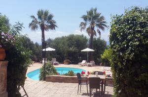 a pool with a table and chairs and palm trees at Property Son Marina in Palma de Mallorca