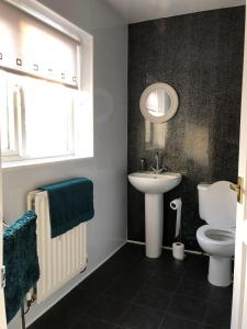 a bathroom with a sink and a toilet and a mirror at Bea's Cottage in Newbiggin-by-the-Sea