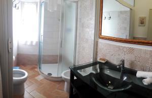 a bathroom with a sink and a shower and a toilet at Agriturismo Le Catre in Castagneto Carducci
