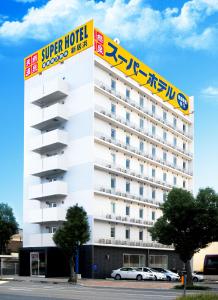 a hotel with a sign on the side of a building at Super Hotel Niihama in Niihama