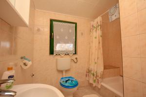 a bathroom with a sink and a toilet and a shower at Apartment Breza in Sućuraj