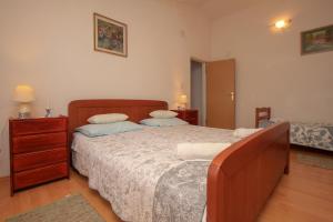 a bedroom with a large bed and a dresser with two pillows at Apartment Breza in Sućuraj