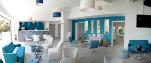a waiting room with blue and white chairs and tables at Hotel La Voile in Bormes-les-Mimosas