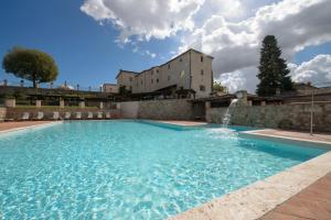 einem Pool mit einem Brunnen vor einem Gebäude in der Unterkunft La Bagnaia Golf Resort in Bagnaia