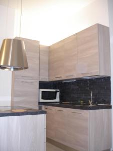 cocina con armarios de madera y microondas en Milan City Center Apartment, en Milán