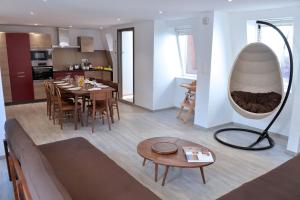 a living room and kitchen with a table and a mirror at Les Suites Du Cygne in Colmar