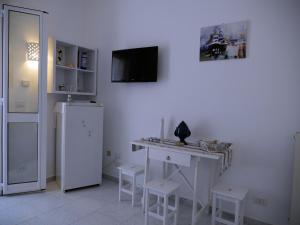 eine weiße Küche mit einem Schreibtisch und einem Kühlschrank in der Unterkunft Pietra di Luna a...mare in Polignano a Mare