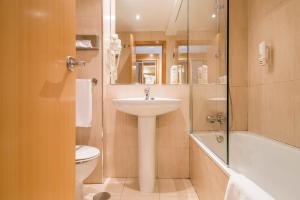 a bathroom with a sink, toilet and bathtub at Infanta Mercedes in Madrid