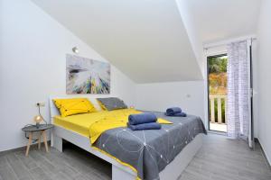 - une chambre avec un lit doté de draps jaunes et une fenêtre dans l'établissement Sea View Luxury Apartments, ALA DA, à Milna