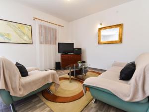 a living room with two chairs and a tv at Serene Holiday Home in Veli I with Fenced Garden in Veli Iž