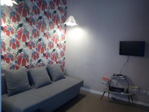 a living room with a couch and a flowered wall at Residenza Navi in Verona