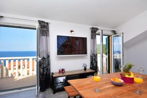 a dining room with a table and a view of the ocean at Sea View Luxury Apartments, ALA DA in Milna