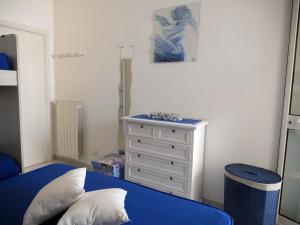 a bedroom with a blue bed and a dresser at Pietra di Luna a...mare in Polignano a Mare
