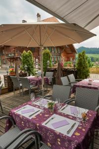 einen Tisch mit einem lila Tischtuch und einem Regenschirm in der Unterkunft Gasthof Bären in Ranflüh