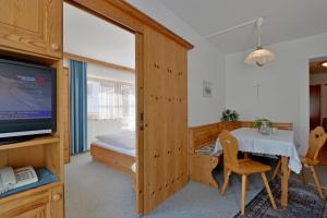 uma sala com uma mesa e uma televisão e um quarto em Gästehaus Elfriede em Mayrhofen